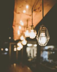 Close-up of illuminated light bulb hanging at restaurant