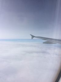 Close-up of airplane wing over sea against sky