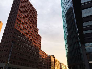 Low angle view of buildings against cloudy sky