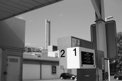 Low angle view of road sign against built structures