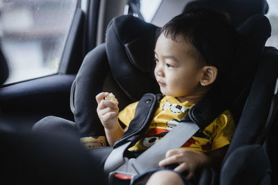 Cute baby boy sitting in car