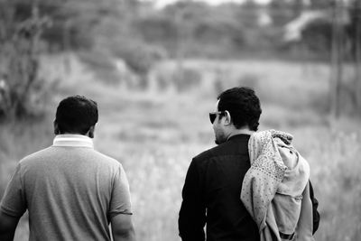 Rear view of men walking on field