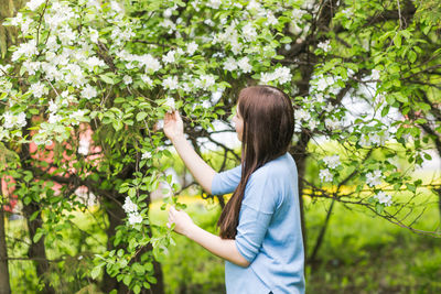 Woman standing by tree