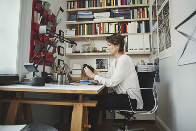 Side view of industrial designer analyzing product at home office