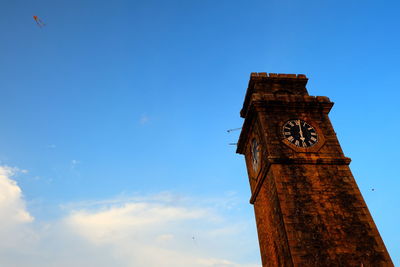 Low angle view of clock tower against blue sky