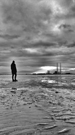 Silhouette man on beach against sky