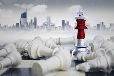 Digital composite image of chess pieces with flag against buildings in city