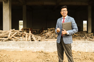 Portrait of a smiling man standing on wood