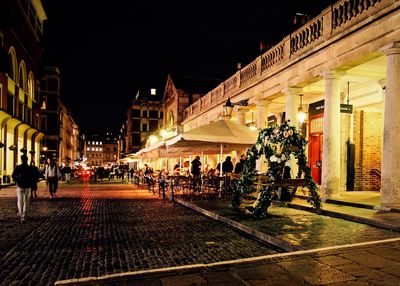 People on illuminated city at night