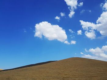 Low angle view of sand dunes against sky