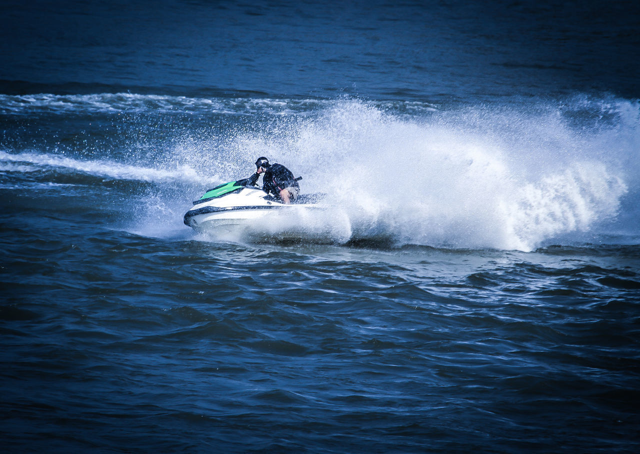 MAN SURFING IN SEA AGAINST WAVES