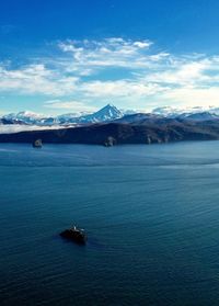 Scenic view of sea and mountains against sky