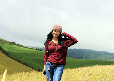 Portrait of smiling young woman standing on field