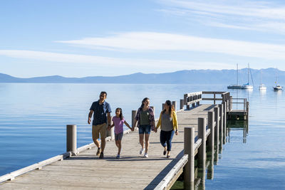 A family walks on a pier on a beautiful day in south lake tahoe, ca