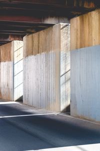 Empty road by building during sunny day