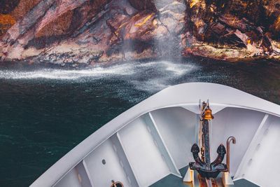 Anchor on ship deck against rock formation in milford sound