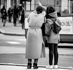 Rear view of women walking on road