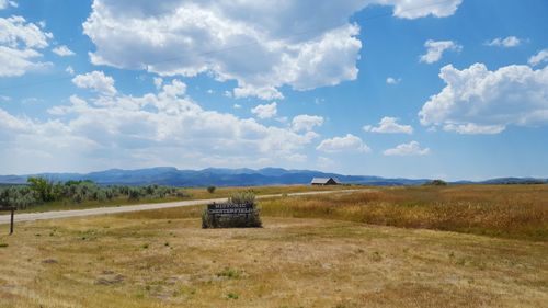 Scenic view of field against cloudy sky