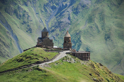 View of historic building against mountain range. gergeti church, stepansmida, caucasus, georgia