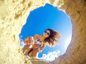 Portrait of young woman relaxing on sand at beach