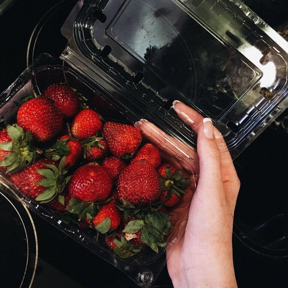 CLOSE-UP OF HAND HOLDING STRAWBERRY
