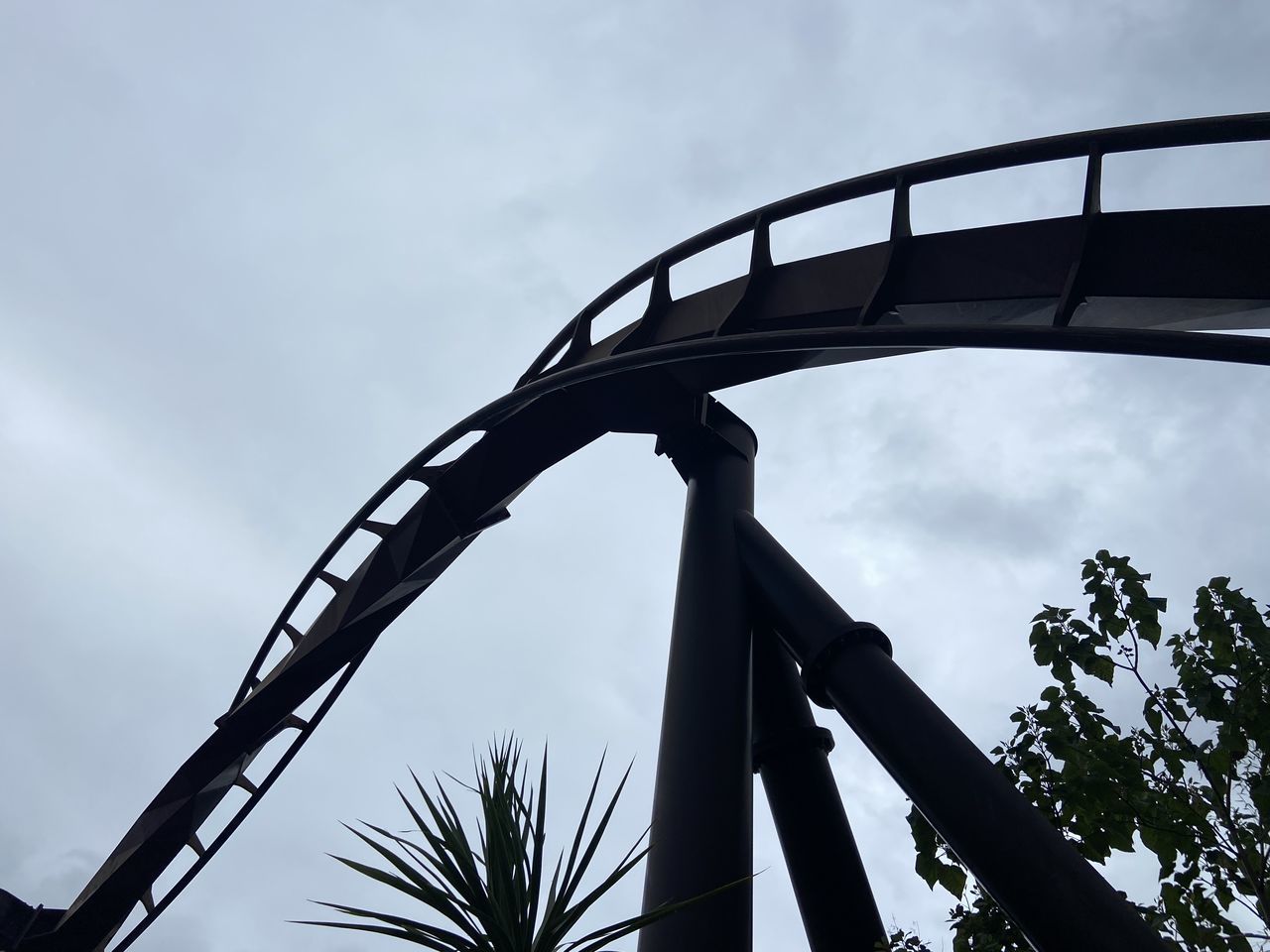 sky, roller coaster, amusement park, low angle view, amusement ride, tree, nature, park, cloud, architecture, recreation, built structure, arts culture and entertainment, plant, no people, outdoors, silhouette, day, amusement park ride