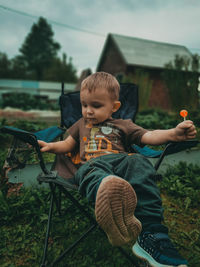 Full length of boy sitting outdoors