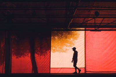 Side view of silhouette man walking against textile