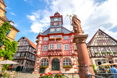 Low angle view of statue amidst buildings against sky