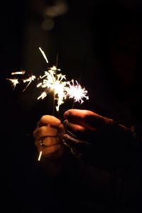 Close-up of hand holding lit candle