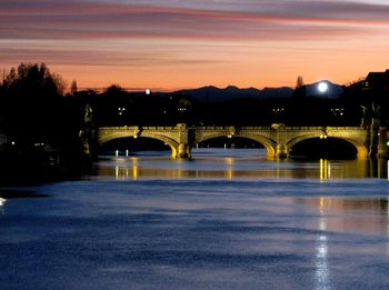 Illuminated bridge against sky during sunset