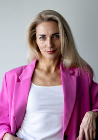 Portrait of young woman standing against white background