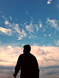 Low angle view of silhouette man standing against sky during sunset