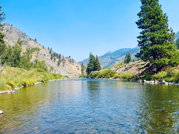 Scenic view of lake against clear blue sky