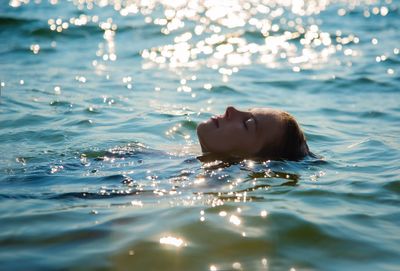 Portrait of young woman swimming in sea