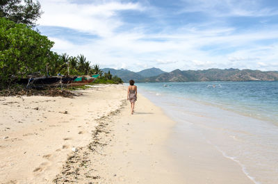 Scenic view of beach against cloudy sky