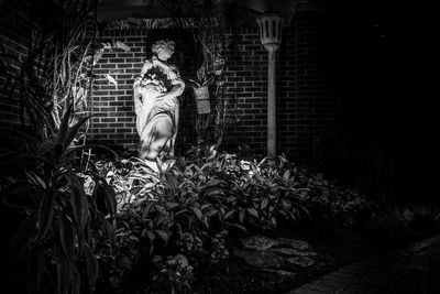 Portrait of woman standing against plants