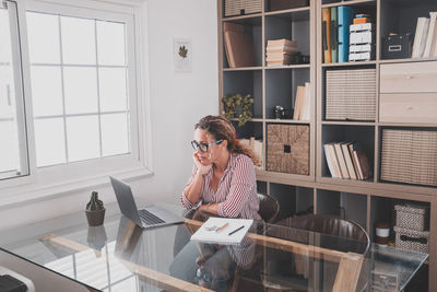 Woman using mobile phone at home
