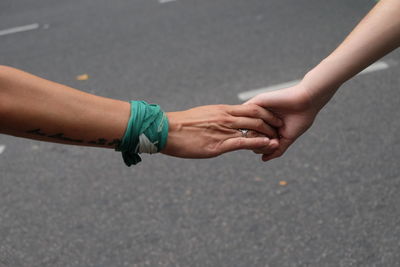 Close up of couple holding hands on street