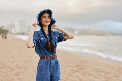 Portrait of young woman standing at beach