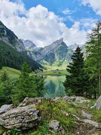 Scenic view of lake by mountains against sky