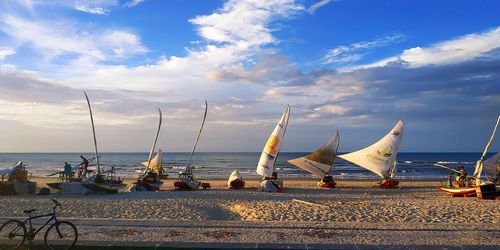 Sailboats on beach against sky