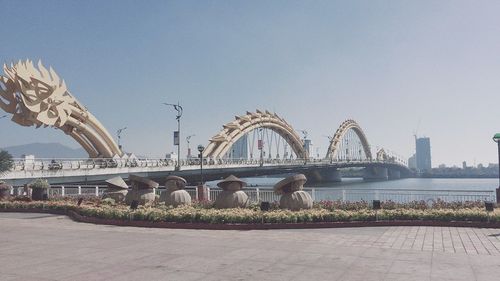 Bridge over river in city against clear sky