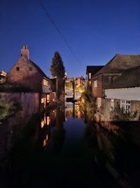 Illuminated buildings against sky at night