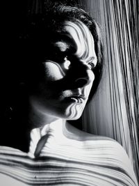 Close-up of thoughtful young woman looking through window