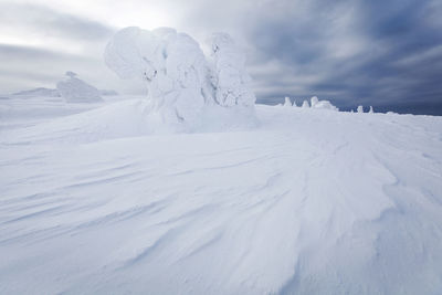 Snow covered landscape against sky