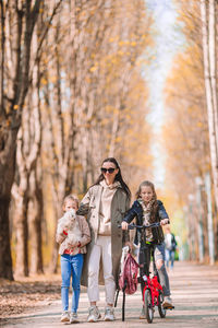 Full length of father with daughter against autumn leaves