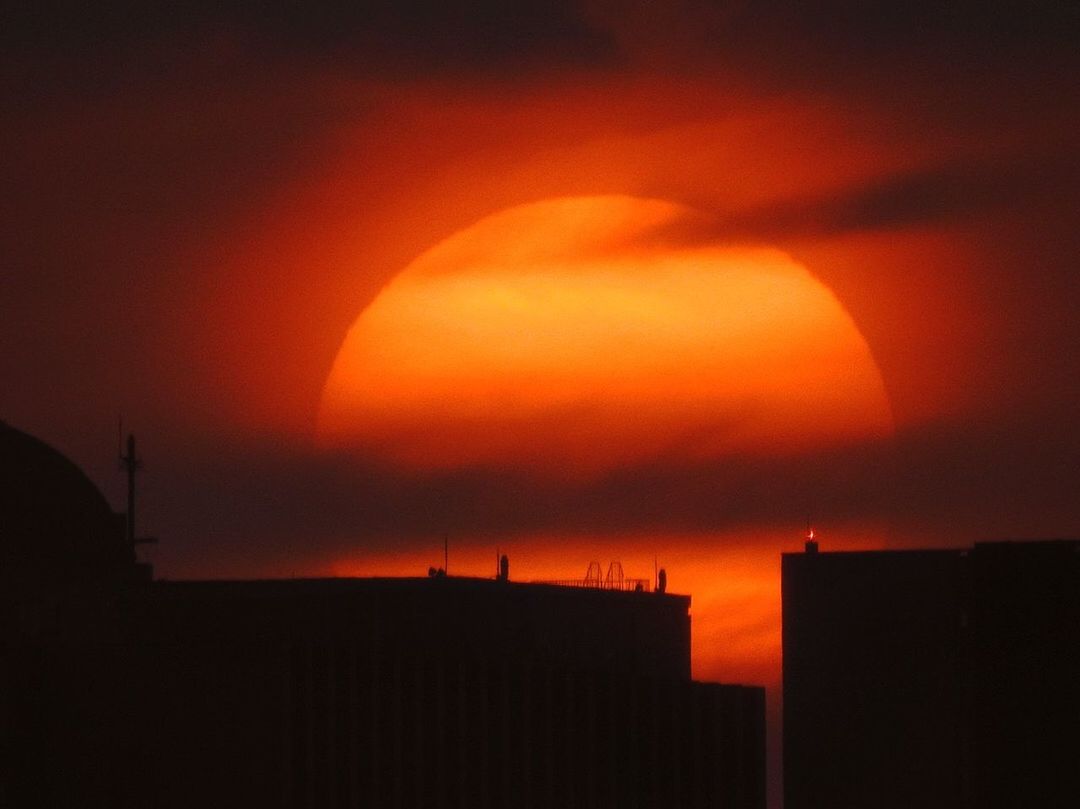 SILHOUETTE BUILDINGS AGAINST ORANGE SKY