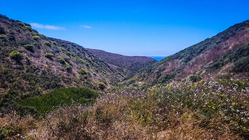 Scenic view of mountains against clear blue sky
