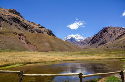 Scenic view of lake and mountains against blue sky